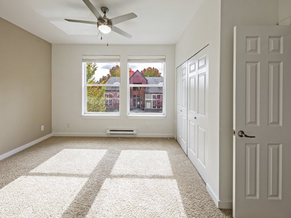 Cozy bedroom with modern decor at Lions Gate North Apartments, featuring a comfortable bed and stylish furniture for a relaxing atmosphere