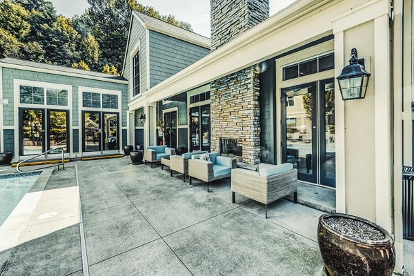 Sunlit pool patio at Bella Vista Apartments with comfortable lounge seating and lush surroundings