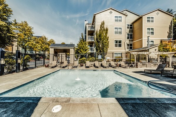 Infinity pool with palm trees at Bella Vista Apartments offering luxury living