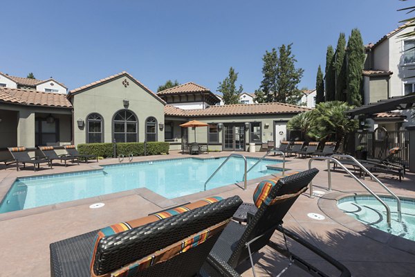 Sparkling outdoor pool with sun loungers at La Terraza Apartments, a luxury living community
