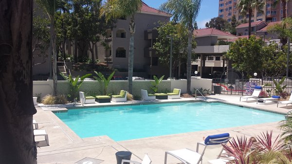 Refreshing outdoor pool at Axiom La Jolla apartments with modern lounge chairs