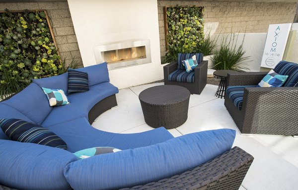 Fire pit lounging area at Axiom La Jolla Apartments with cozy seating and ambient night lighting