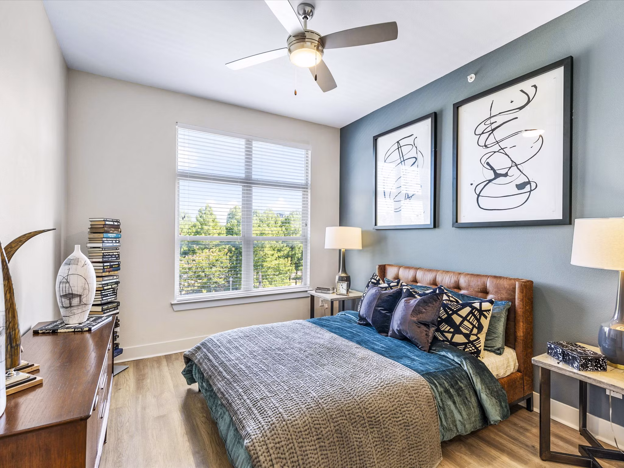 Modern bedroom with sleek design and large windows in Ambrose Apartments, a luxury location by Greystar