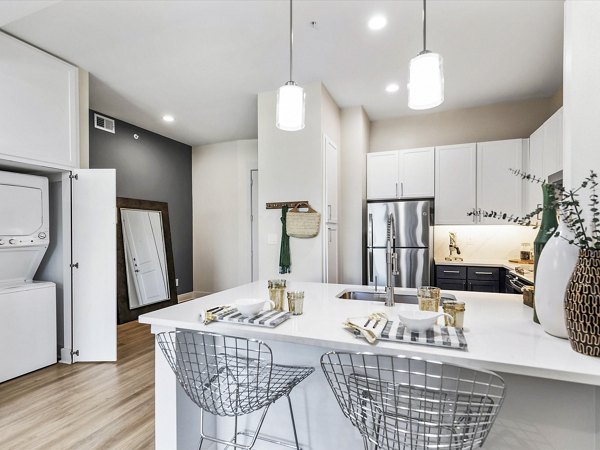 Modern kitchen with granite countertops and stainless steel appliances in Ambrose Apartments' luxury community