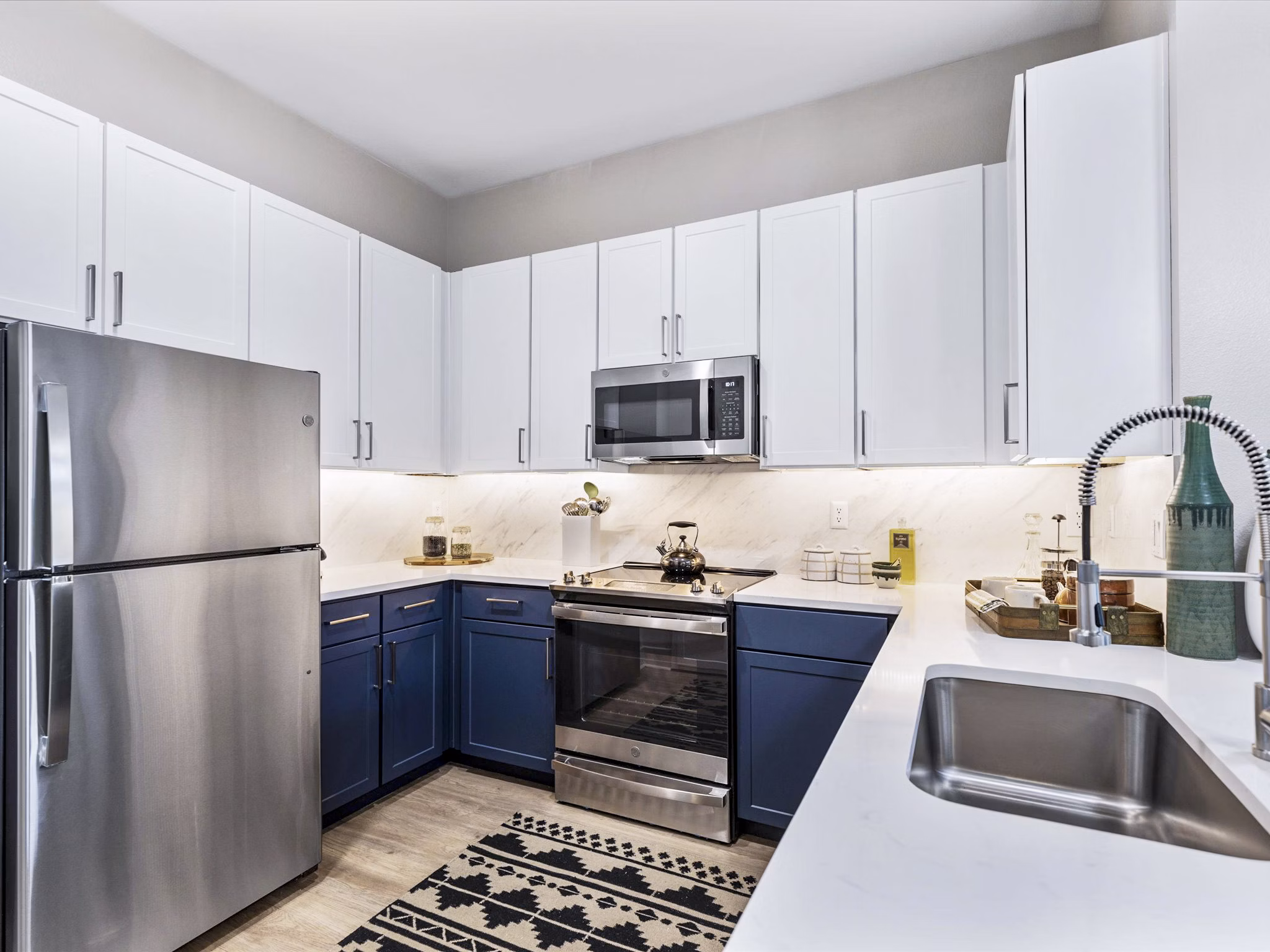 Modern kitchen with granite countertops and stainless steel appliances at Ambrose Apartments