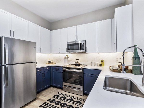 Modern kitchen with granite countertops and stainless steel appliances at Ambrose Apartments