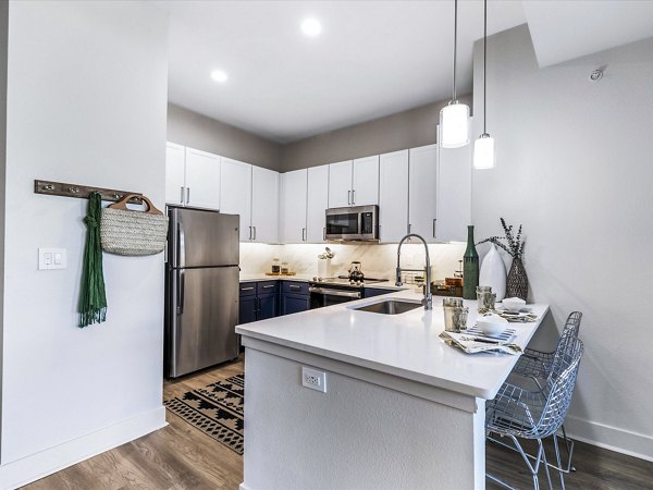 Modern kitchen with stainless steel appliances and granite countertops at Ambrose Apartments
