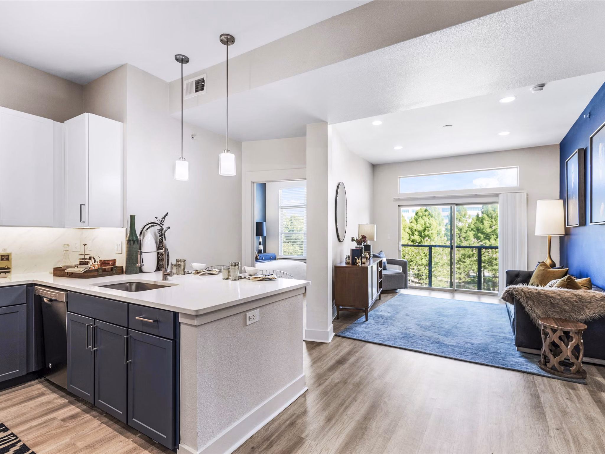 Cozy living room with modern furniture and large windows at Ambrose Apartments, featuring luxury amenities for comfortable living in a Greystar community