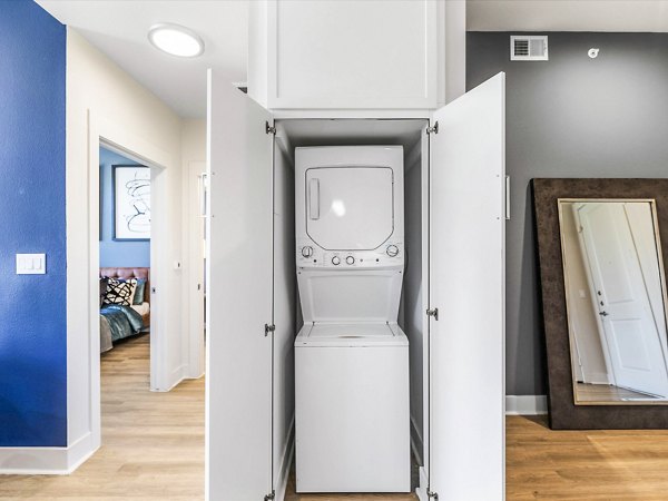 Laundry room featuring modern appliances at Ambrose Apartments