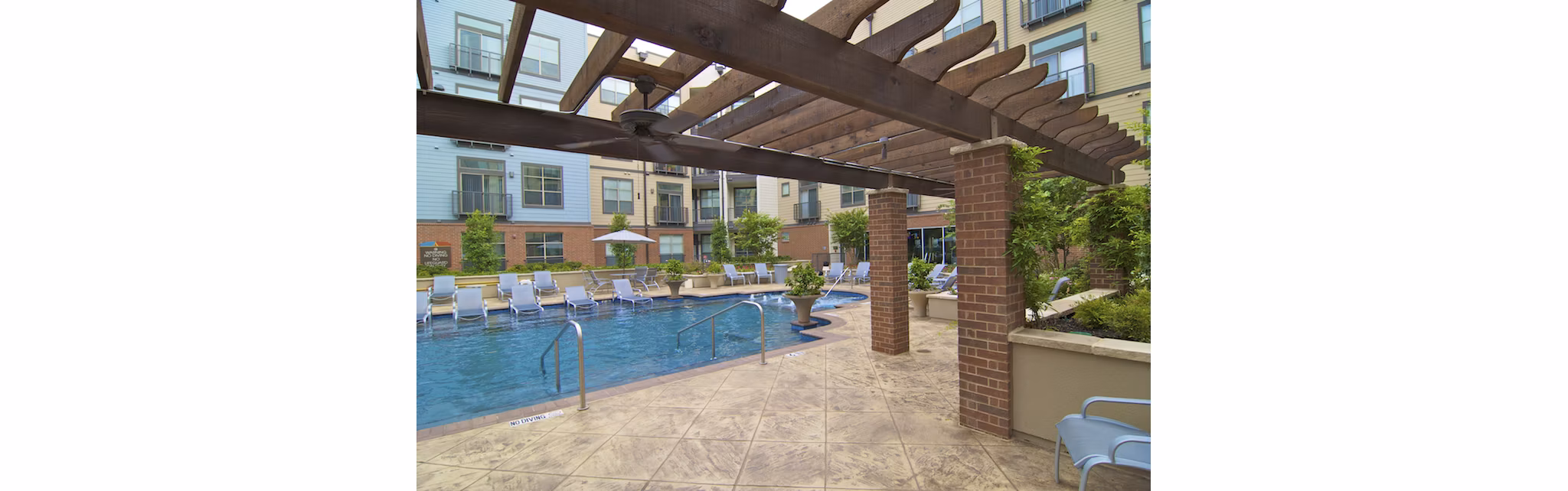 Rooftop pool with lounge chairs at Broadstone Ambrose luxury apartments, perfect for relaxation and leisure activities