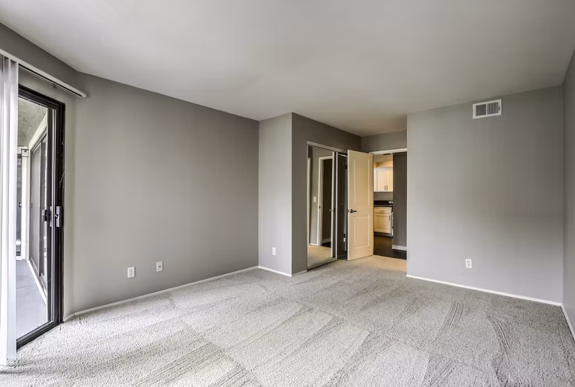 Bedroom with modern decor and large windows in Flower Fields Apartments
