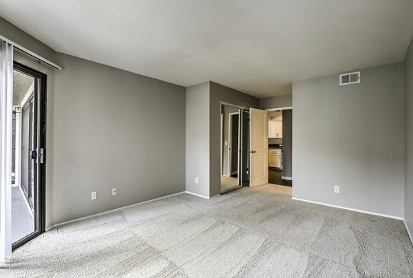 Bedroom with modern decor and large windows in Flower Fields Apartments