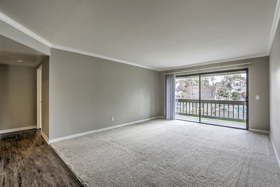 Cozy living room with plush seating and natural light at Flower Fields Apartments