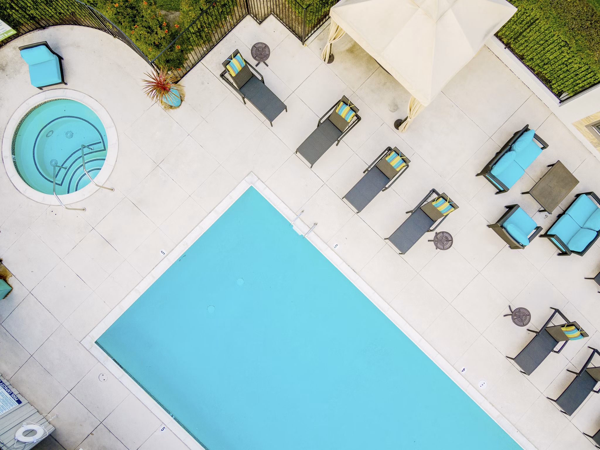 Refreshing outdoor pool at Flower Fields Apartments, offering luxury relaxation in a beautifully landscaped setting