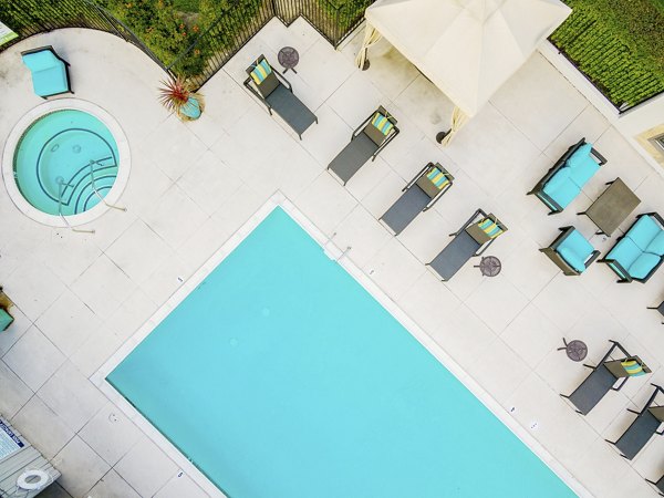 Refreshing outdoor pool at Flower Fields Apartments, offering luxury relaxation in a beautifully landscaped setting