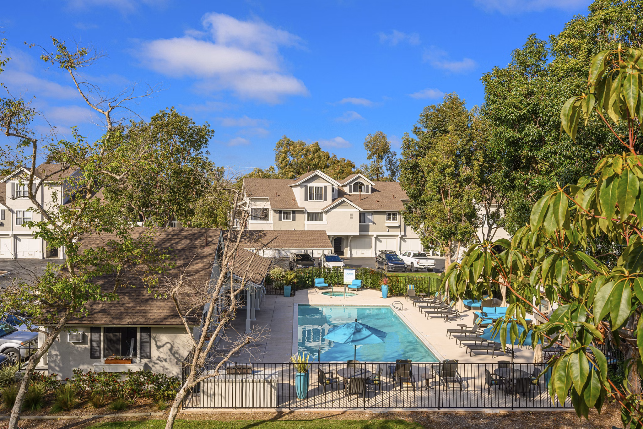Luxury pool at Flower Fields Apartments with sun loungers and shaded seating areas, perfect for relaxation and enjoyment