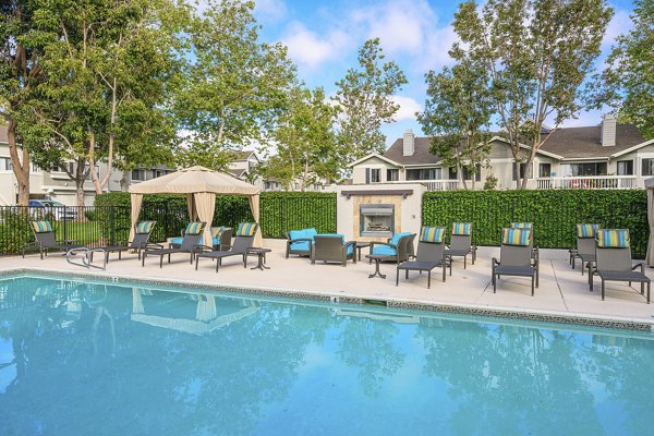 Resort-style pool with palm trees at Flower Fields Apartments, offering luxury living in a serene environment