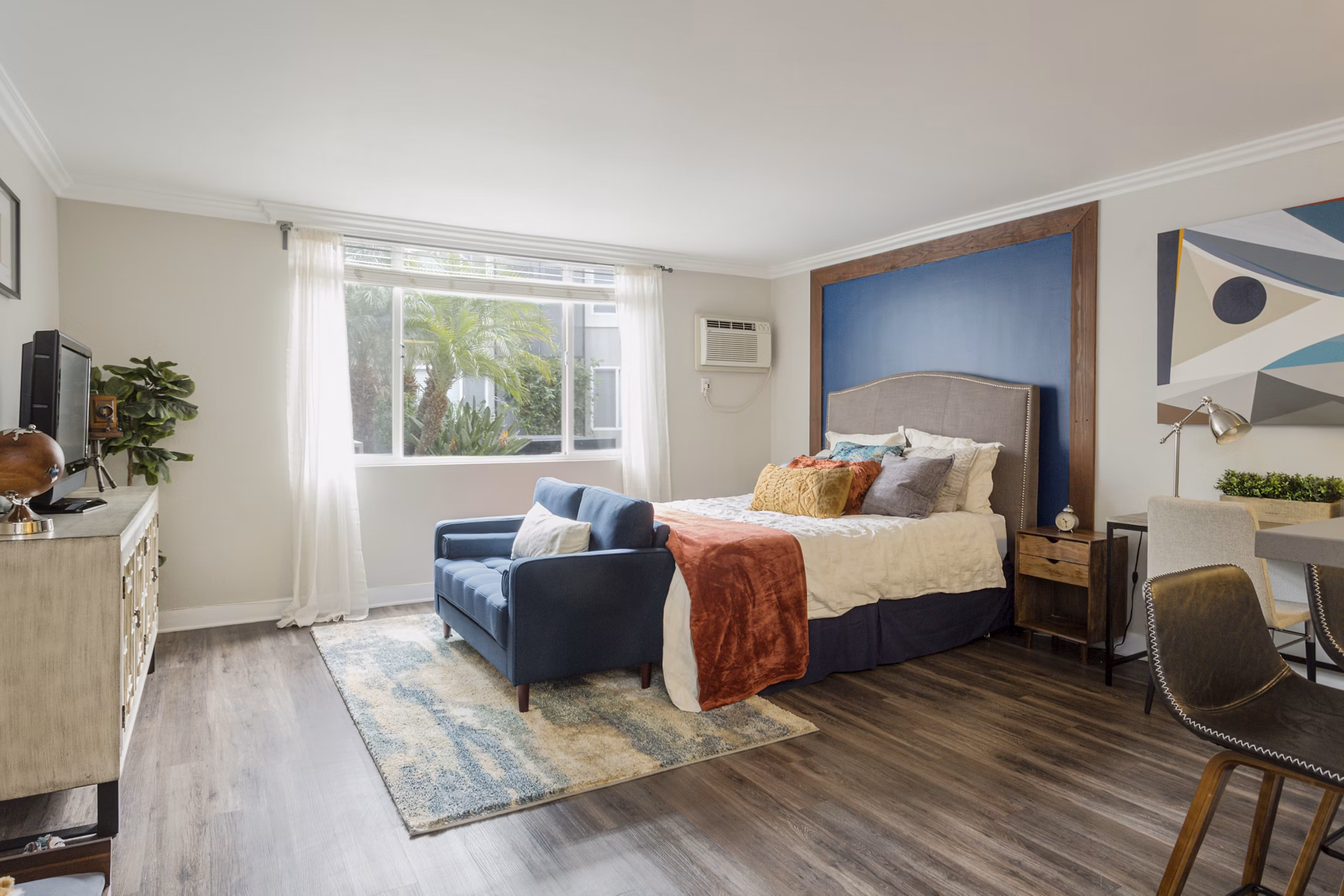 Bright bedroom with river views at 1200 Riverside Apartments, featuring elegant furnishings and ample natural light