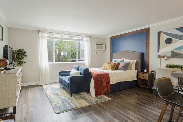 Bright bedroom with river views at 1200 Riverside Apartments, featuring elegant furnishings and ample natural light