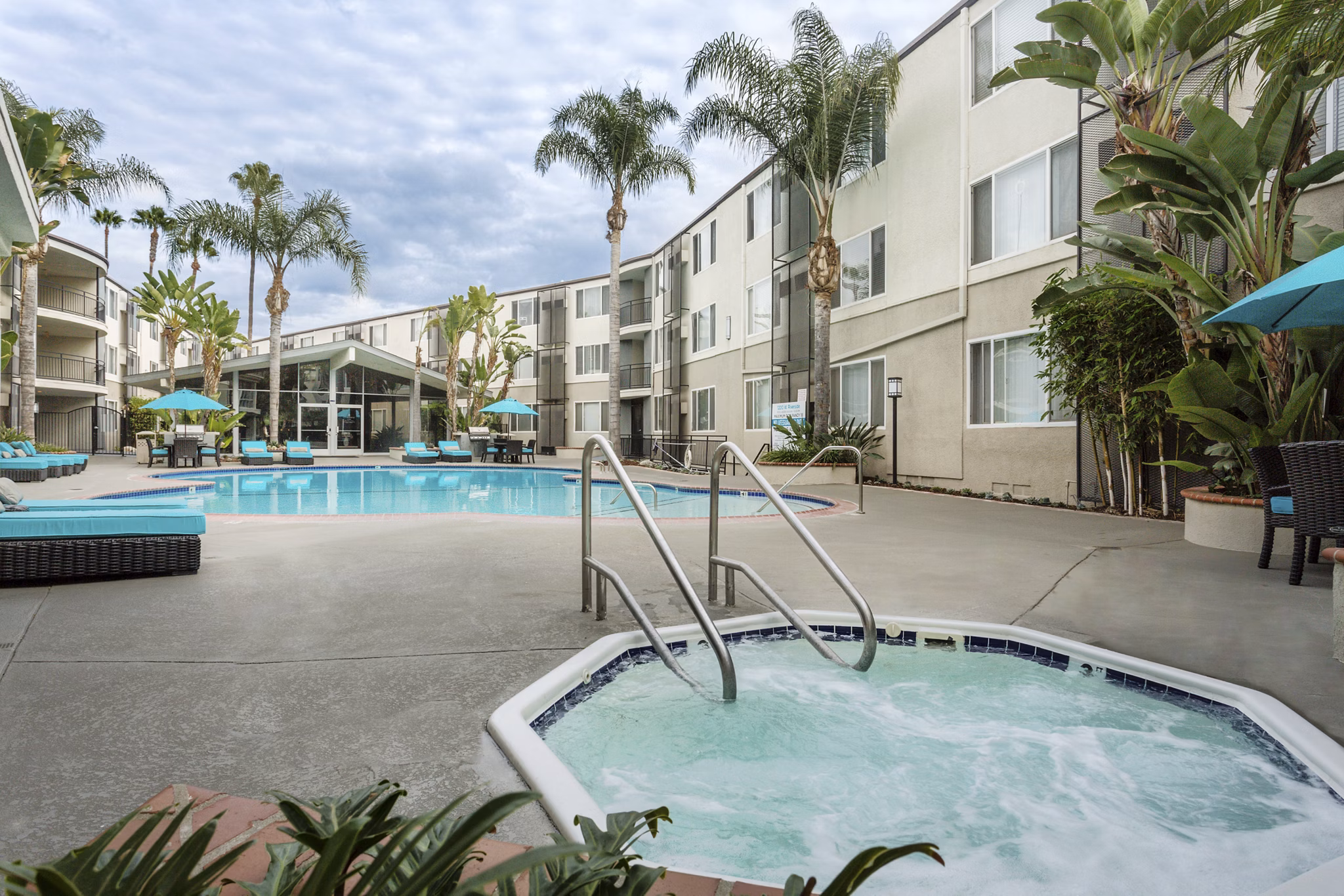 Outdoor pool surrounded by lush landscaping at 1200 Riverside Apartments