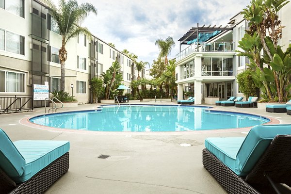 Serene outdoor pool with lounge area at 1200 Riverside Apartments, perfect for relaxation and leisure activities
