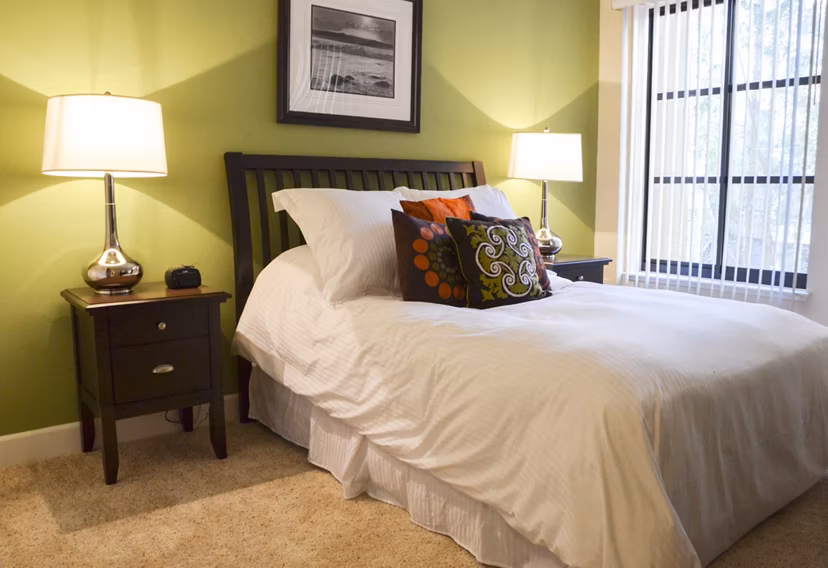 The Windsor Apartments: Modern bedroom with elegant furnishings and large windows for luxury living