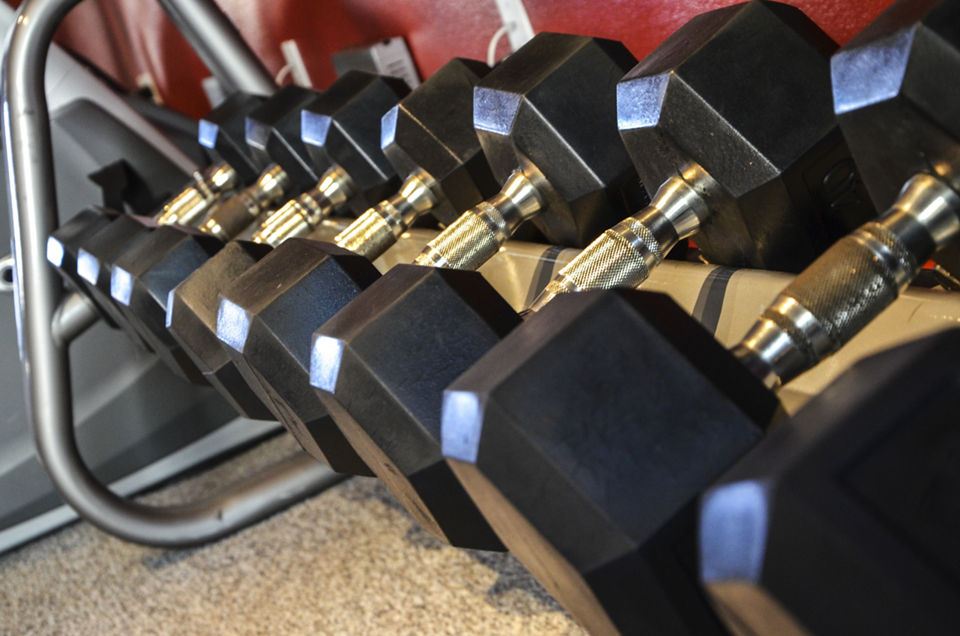 Fitness room with modern equipment at The Windsor Apartments, featuring cardio machines and free weights for a healthy lifestyle