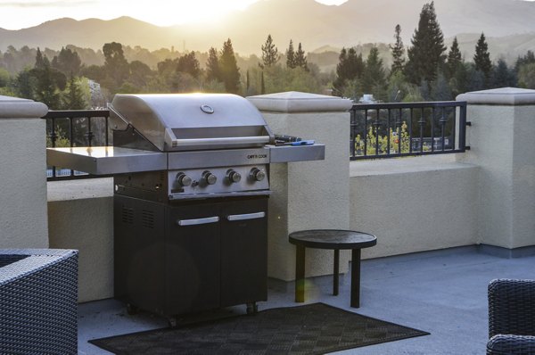 Outdoor grill area with modern seating at The Windsor Apartments, perfect for entertaining and dining al fresco