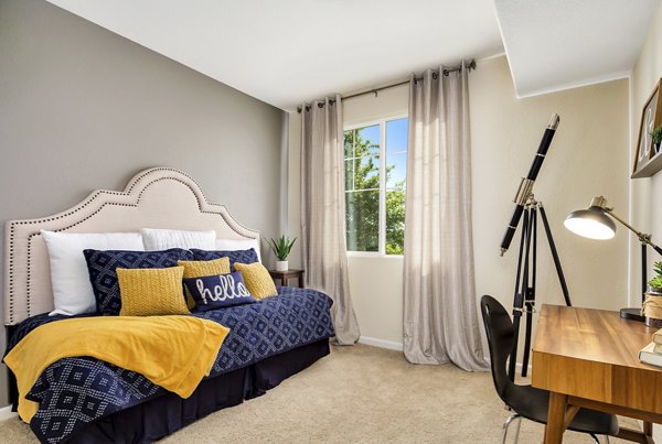 Cozy bedroom with large windows at Montessa At Whitney Ranch Apartments in a luxury setting
