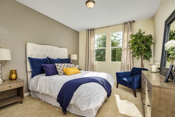 Bedroom with elegant decor and plush bedding at Montessa At Whitney Ranch Apartments