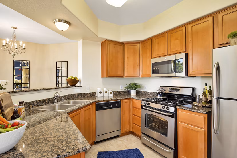 Modern kitchen with granite countertops and stainless steel appliances in Montessa At Whitney Ranch Apartments