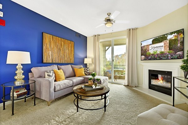 Modern living room with cozy seating and abundant natural light at Montessa At Whitney Ranch Apartments