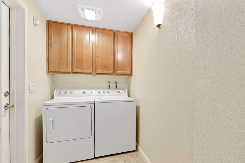 Laundry room with high-efficiency washers and dryers at Montessa At Whitney Ranch Apartments