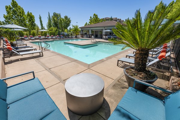 Inviting outdoor pool with palm trees at Montessa at Whitney Ranch Apartments offering luxury living in a serene setting