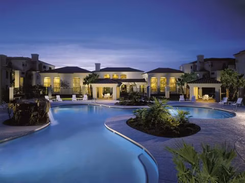 Relaxing outdoor pool at San Cierra Apartments with lush landscaping and modern lounge chairs for residents to enjoy Delaware's sunny days