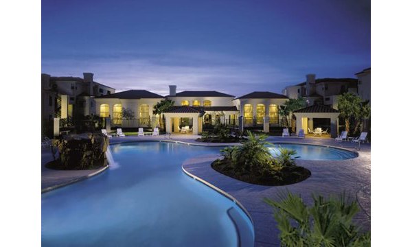 Relaxing outdoor pool at San Cierra Apartments with lush landscaping and modern lounge chairs for residents to enjoy Delaware's sunny days