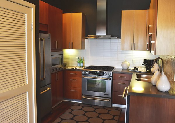 Modern kitchen featuring stainless steel appliances and granite countertops at NoHo 14 Apartments