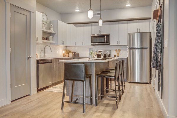 Kitchen featuring modern appliances and granite countertops in Bria Apartments
