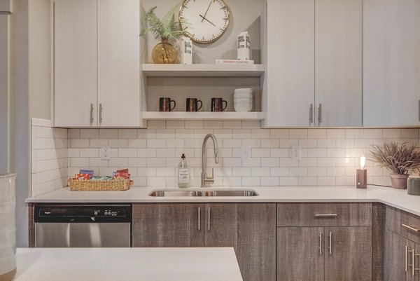 Modern kitchen with stainless steel appliances and granite countertops at Bria Apartments