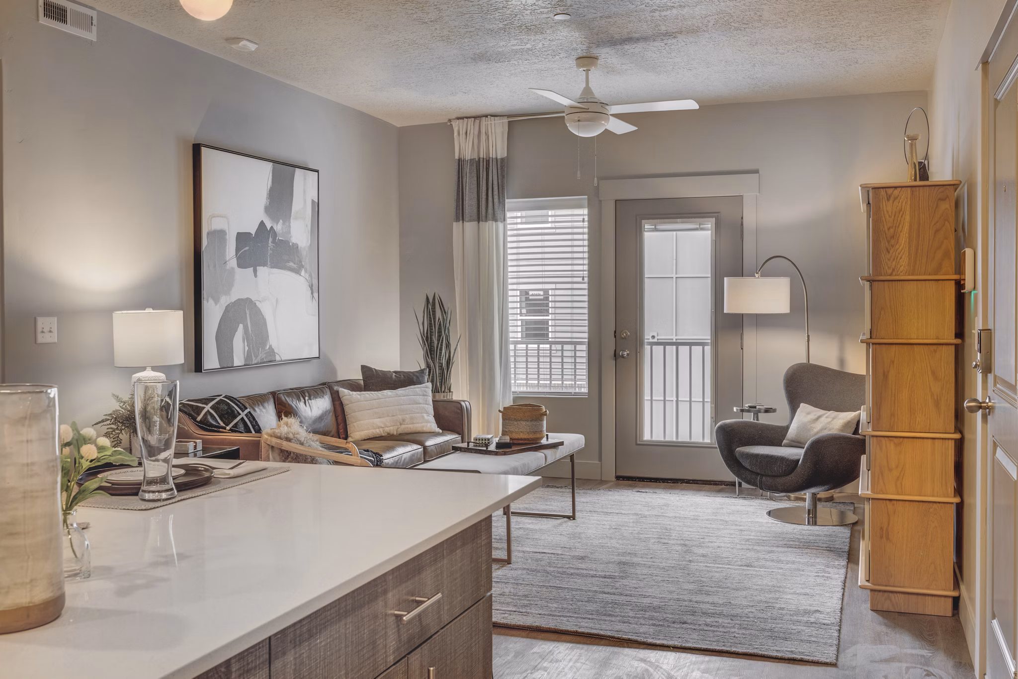 Spacious living room featuring modern furniture and large windows in Bria Apartments