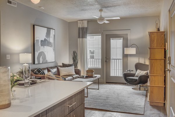 Spacious living room featuring modern furniture and large windows in Bria Apartments