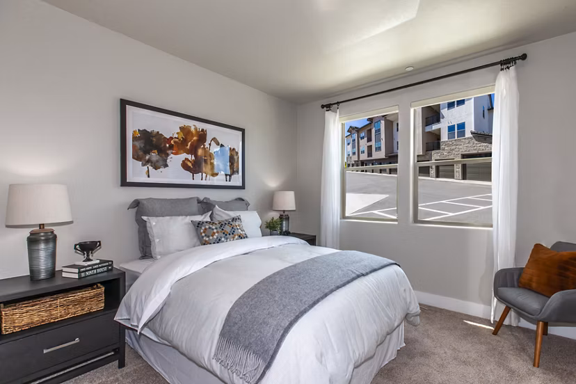 Cozy bedroom with modern decor at Adega Apartments, a Greystar luxury community