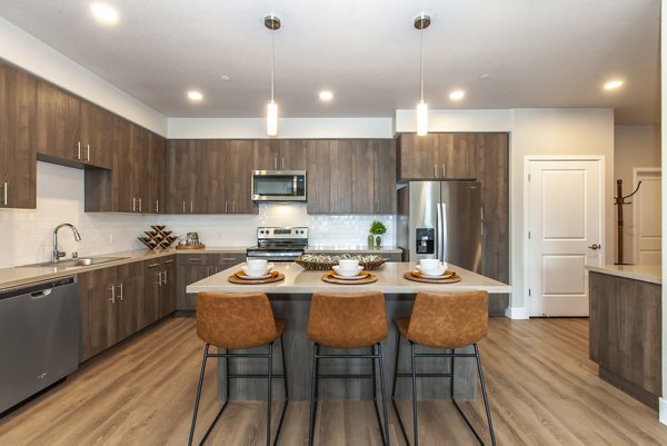 Modern kitchen with stainless steel appliances in Adega Apartments
