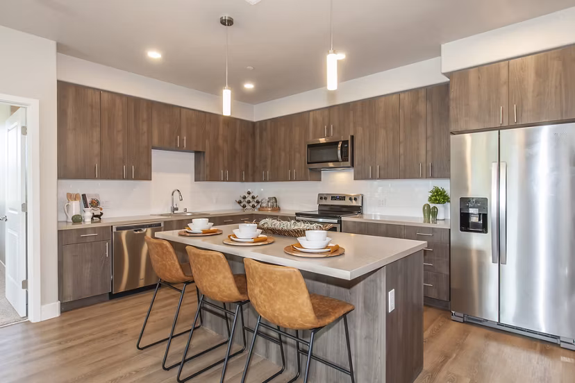 Modern kitchen with stainless steel appliances in Adega Apartments