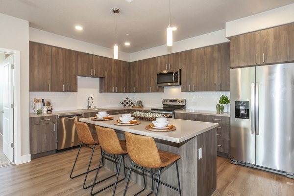 Modern kitchen with stainless steel appliances in Adega Apartments