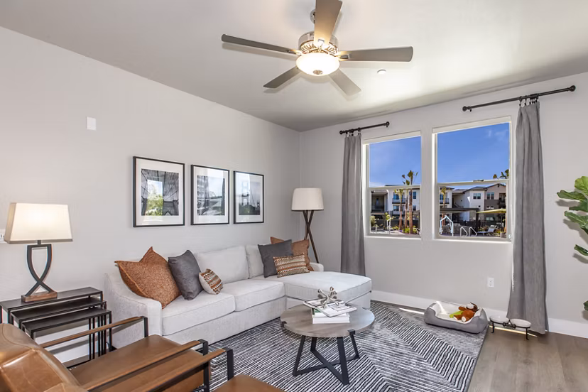 Modern living room with natural light and sleek furnishings at Adega Apartments, luxury residences by Greystar