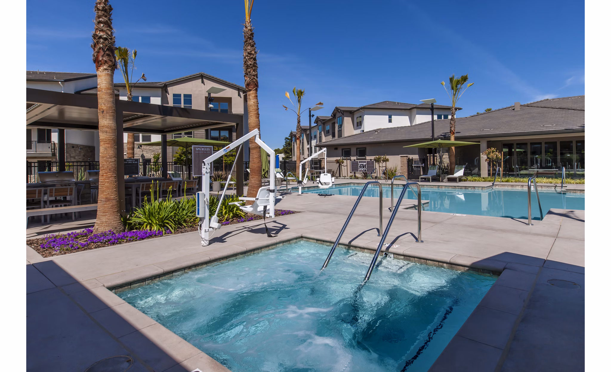 Resort-style pool with lounge chairs at Adega Apartments