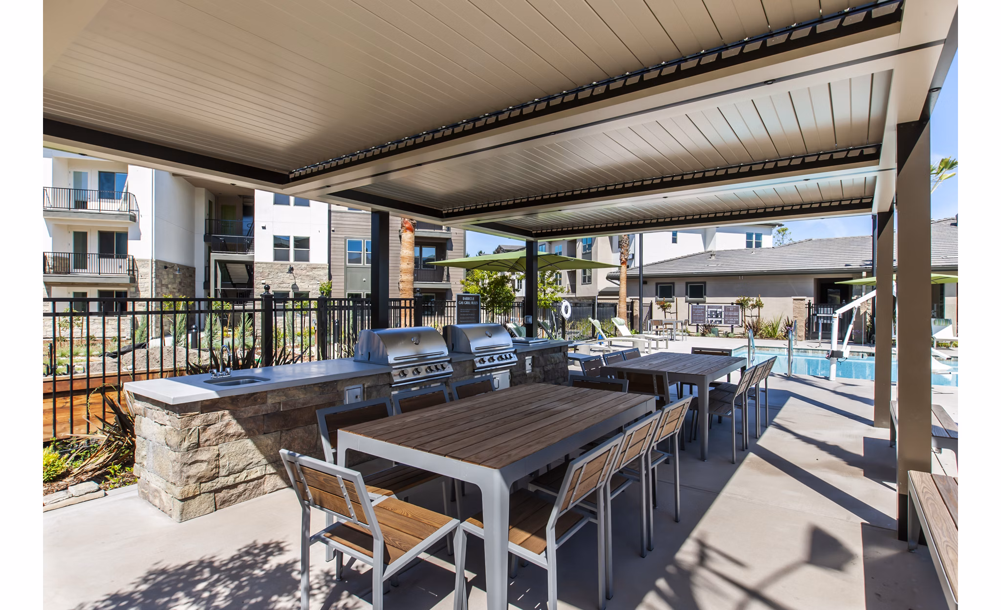 Outdoor grill area with modern seating at Adega Apartments, a luxury community managed by Greystar