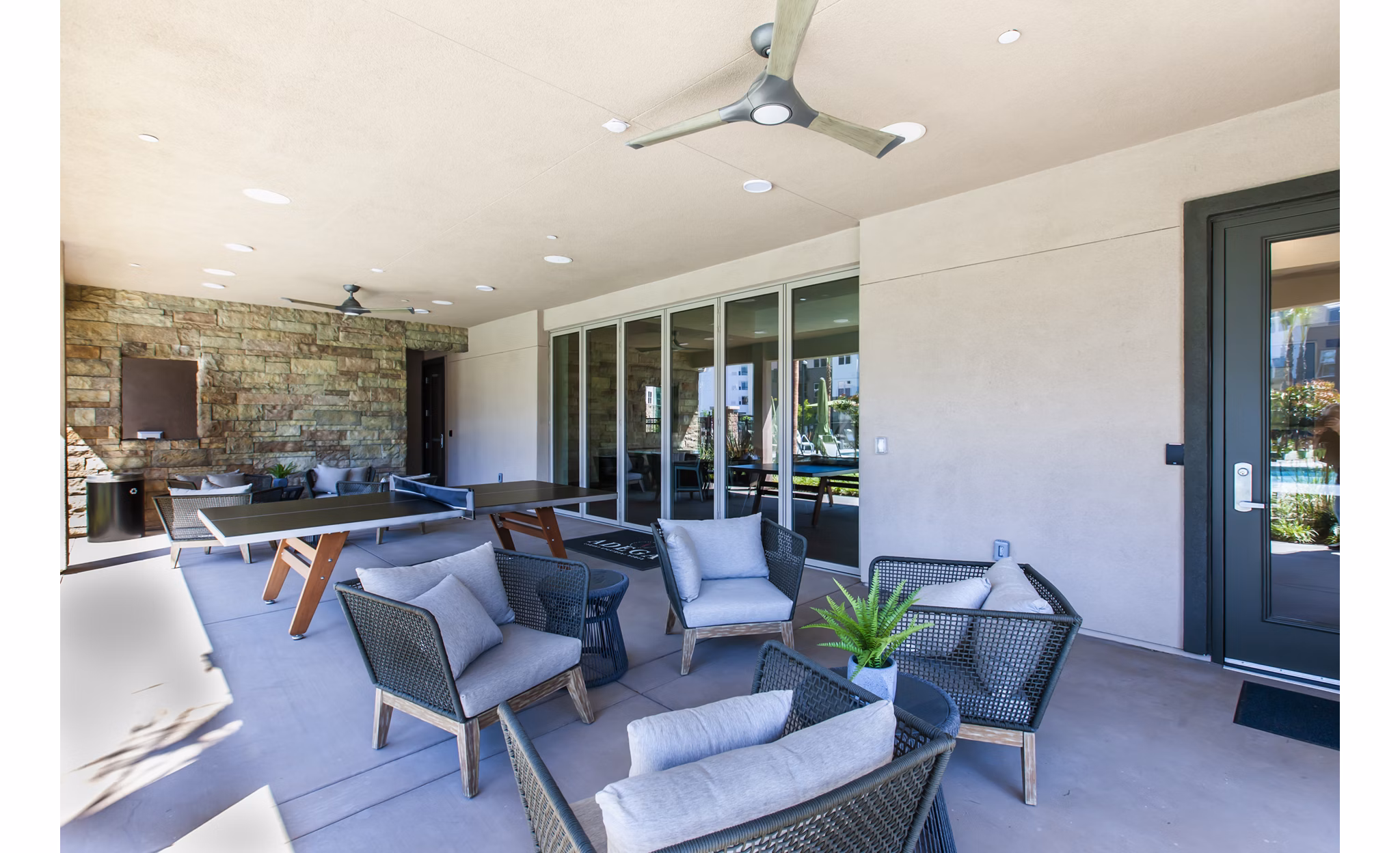Stylish patio with modern seating and lush greenery at Adega Apartments, perfect for relaxation and outdoor gatherings
