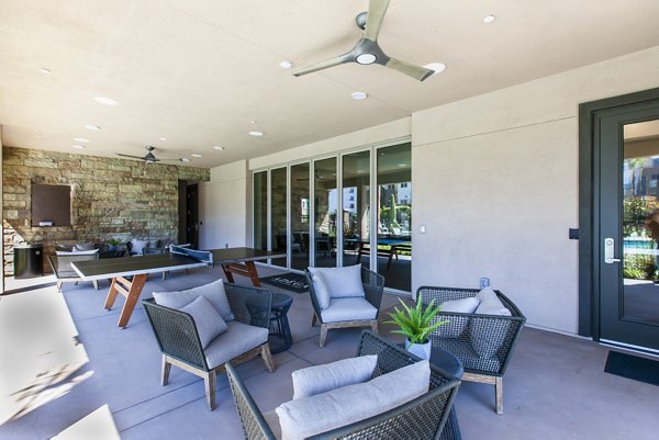 Stylish patio with modern seating and lush greenery at Adega Apartments, perfect for relaxation and outdoor gatherings